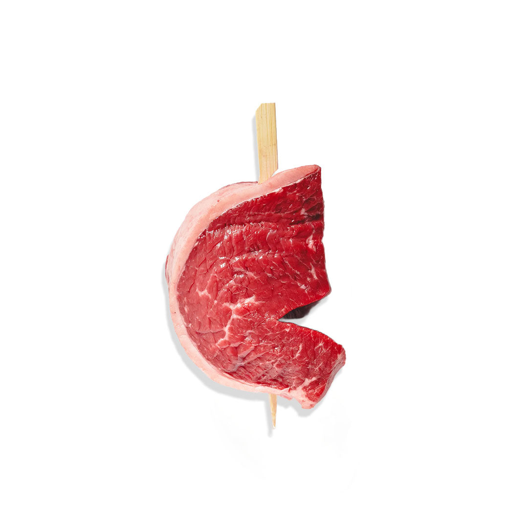 Raw steak on a wooden skewer against a white background