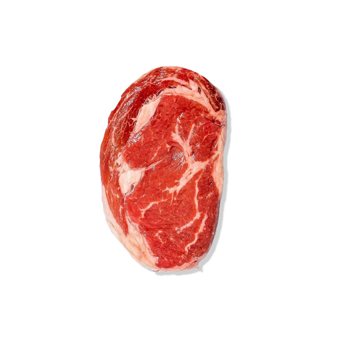 Angus Ribeye steak with marbling, seared to medium-rare, garnished with butter and thyme