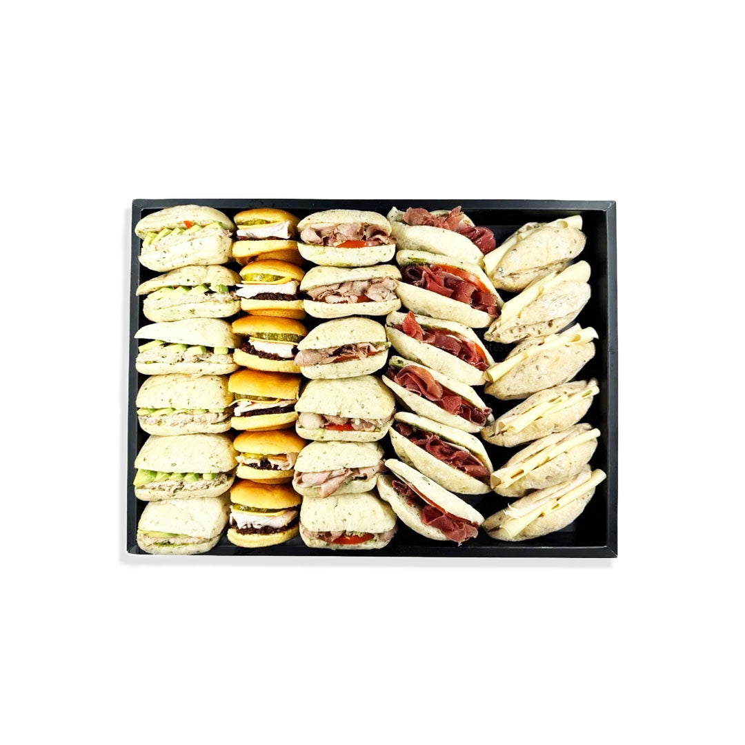 Assorted mini sandwiches in a black box on a white background