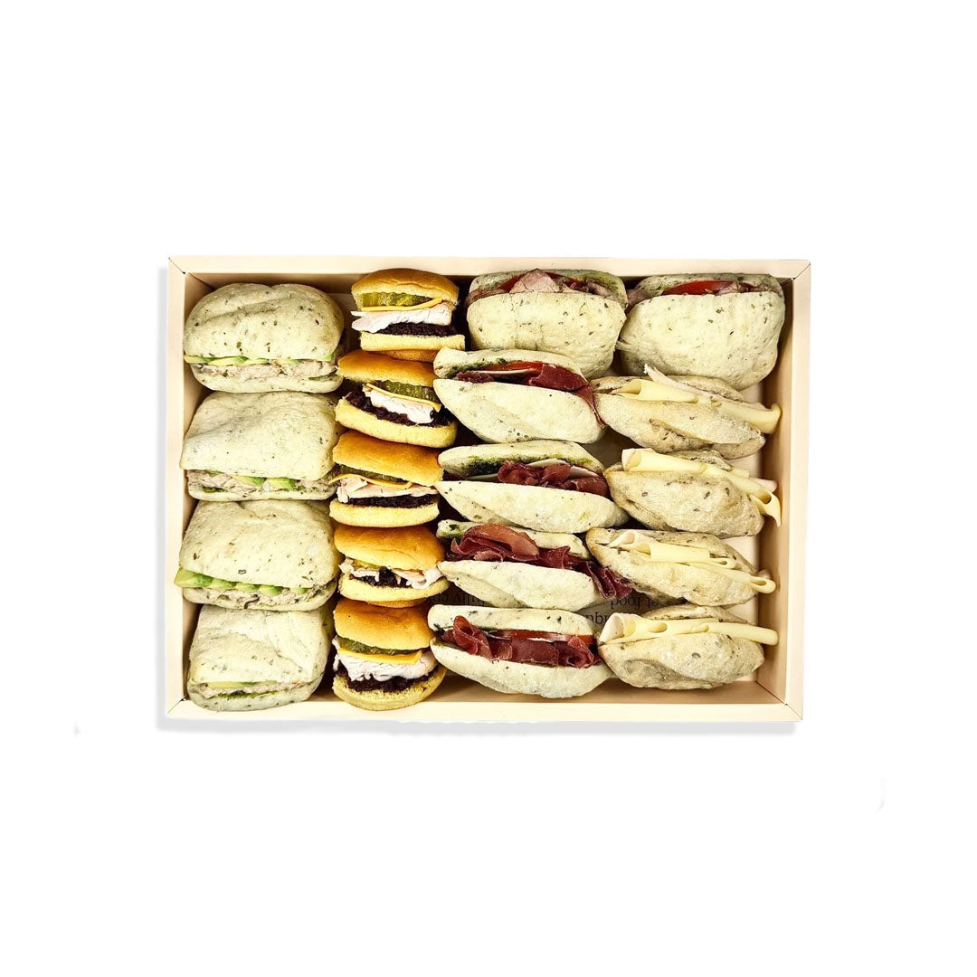 Assorted sandwiches in a wooden box on a white background