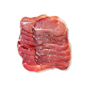 Thinly sliced air-dried beef bresaola with olive oil and lemon on a gourmet platter