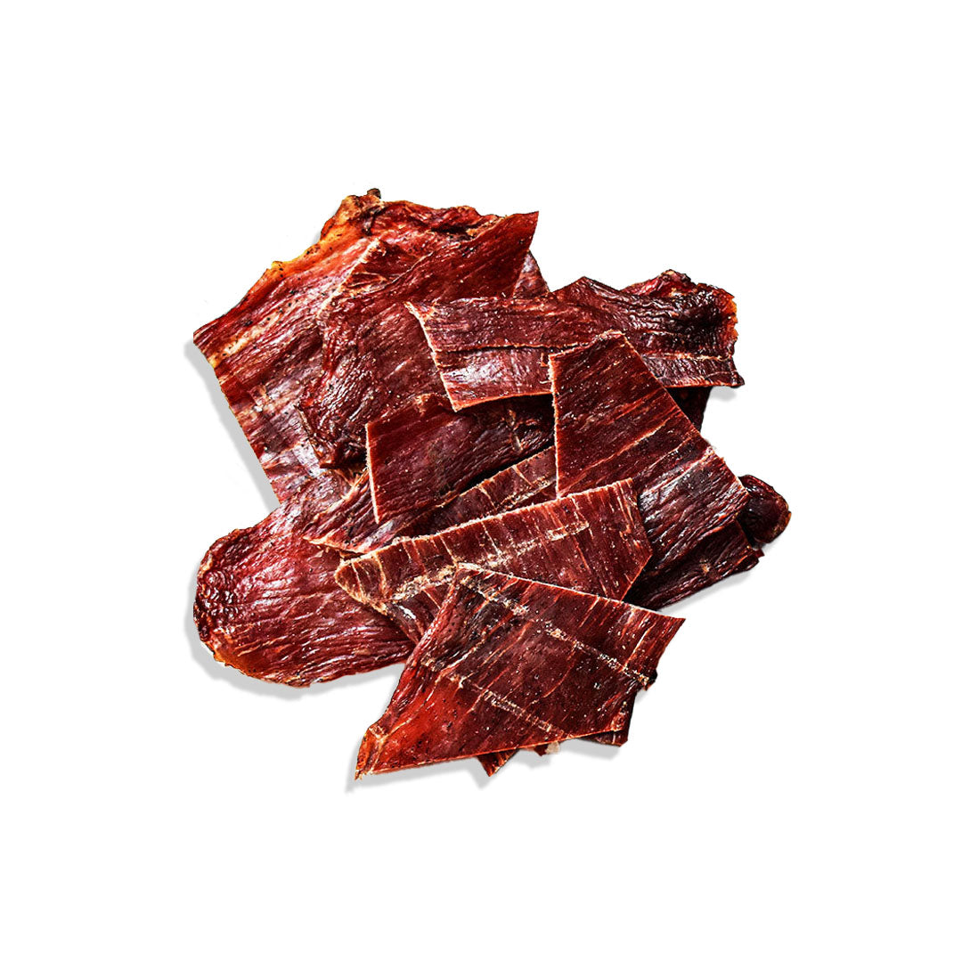 Dried beef jerky pieces on a white background