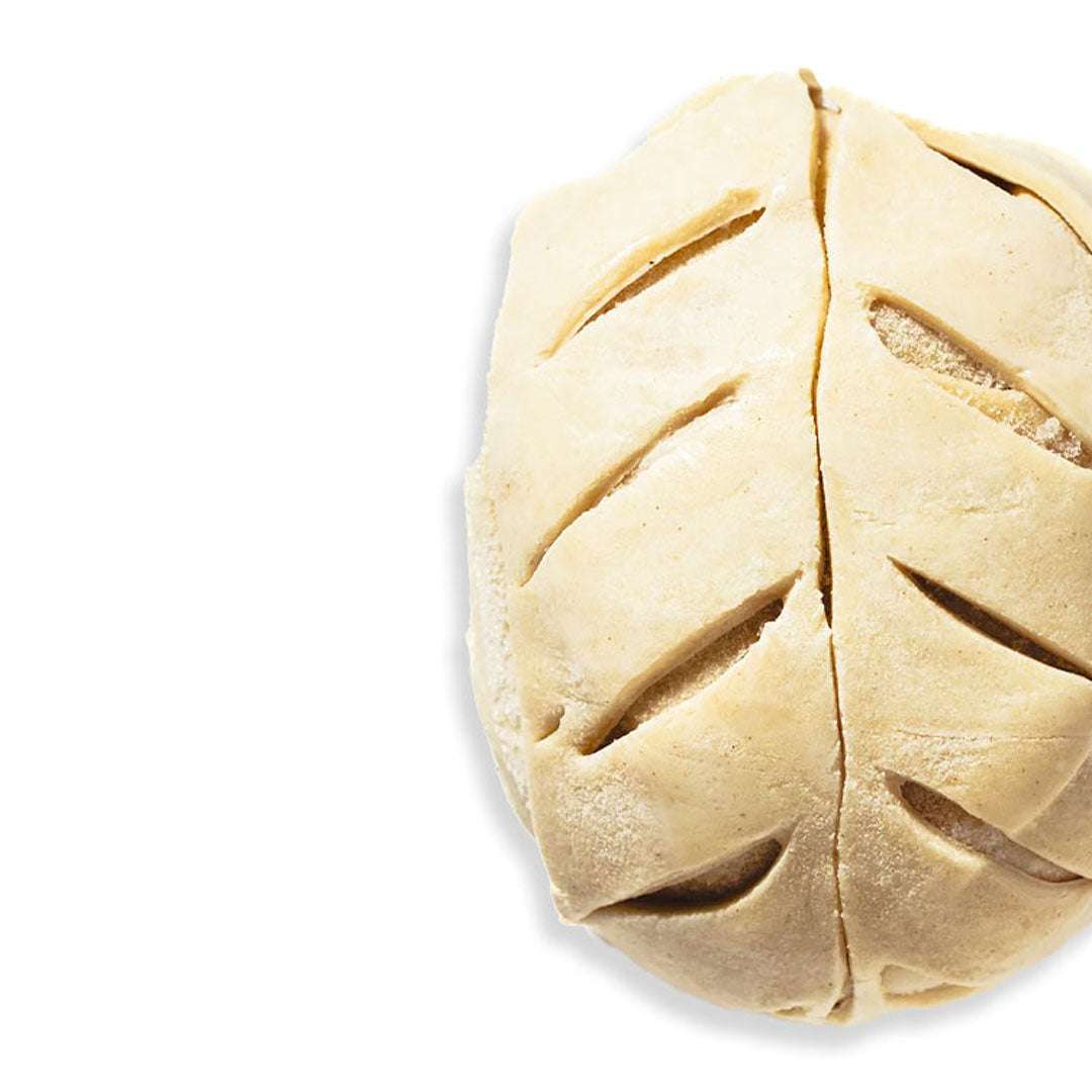 Unbaked pie with decorative crust on a white background