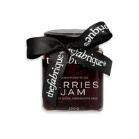 Jar of berries jam with a black ribbon on a white background