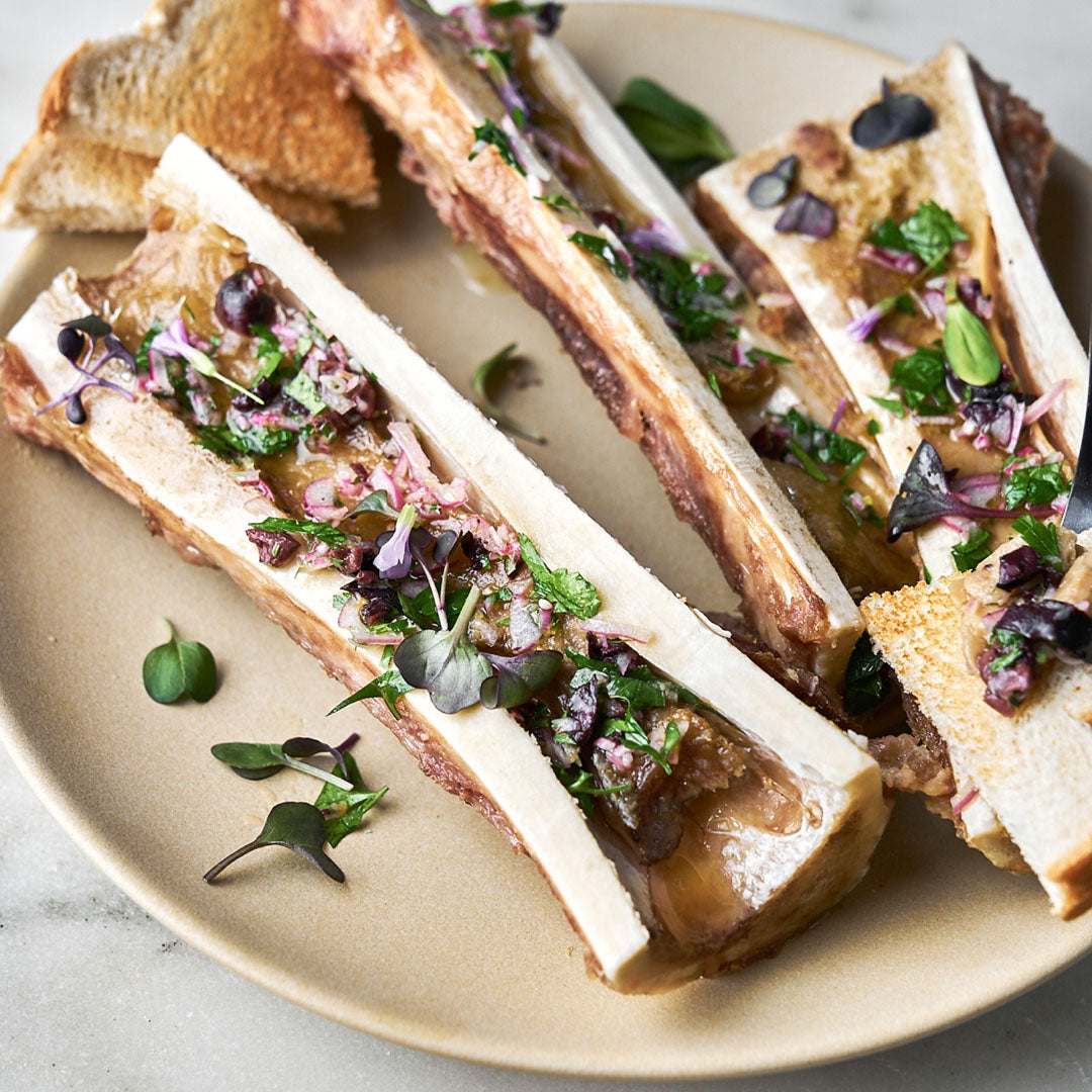 Bread slices with meat and garnishes on a beige plate