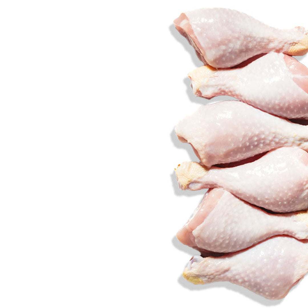 Raw chicken drumsticks on a white background