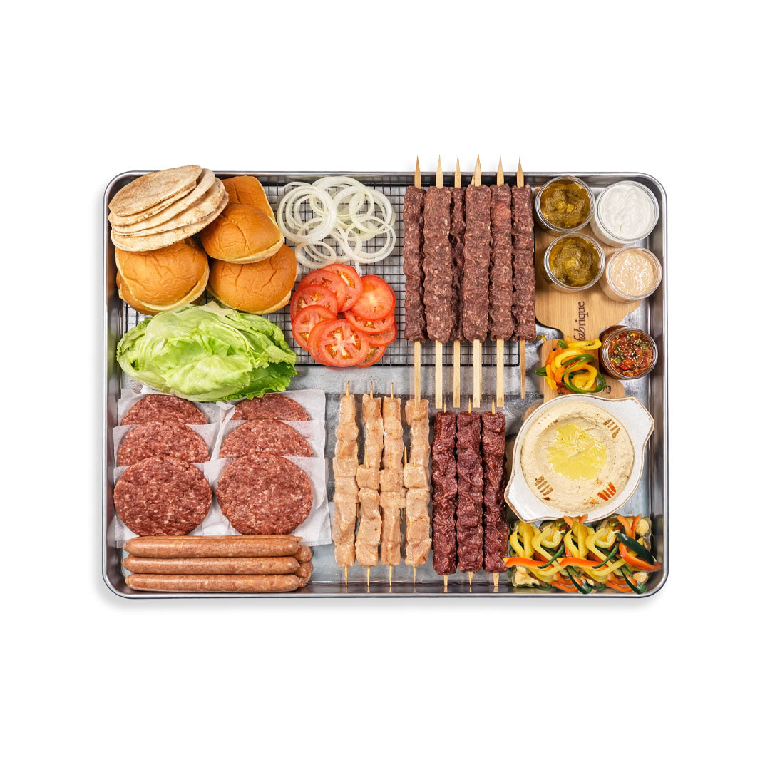 Assorted meats, vegetables, and condiments on a platter with buns on a white background