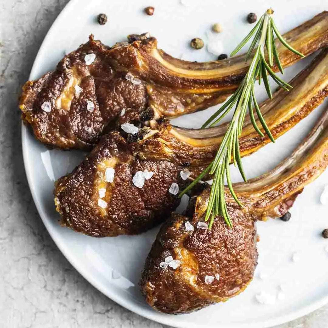 Rack of lamb with rosemary on a white plate