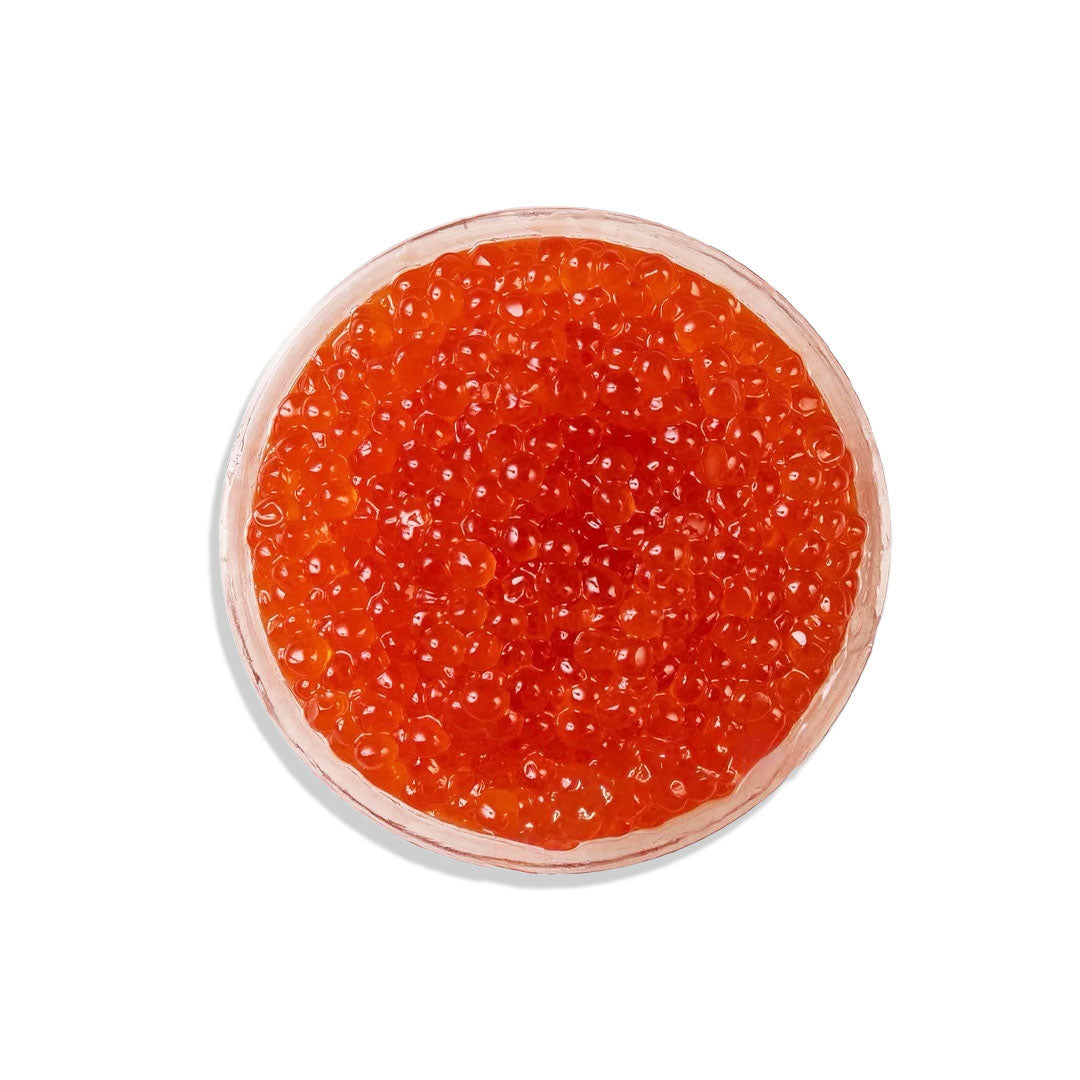 Red caviar in a small glass container on a white background