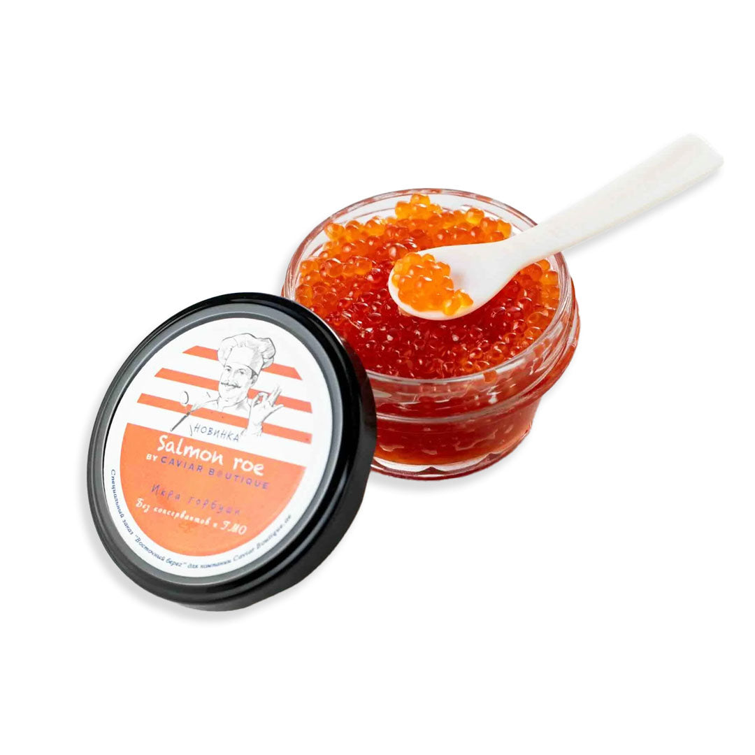 Jar of salmon roe with a spoon on a white background