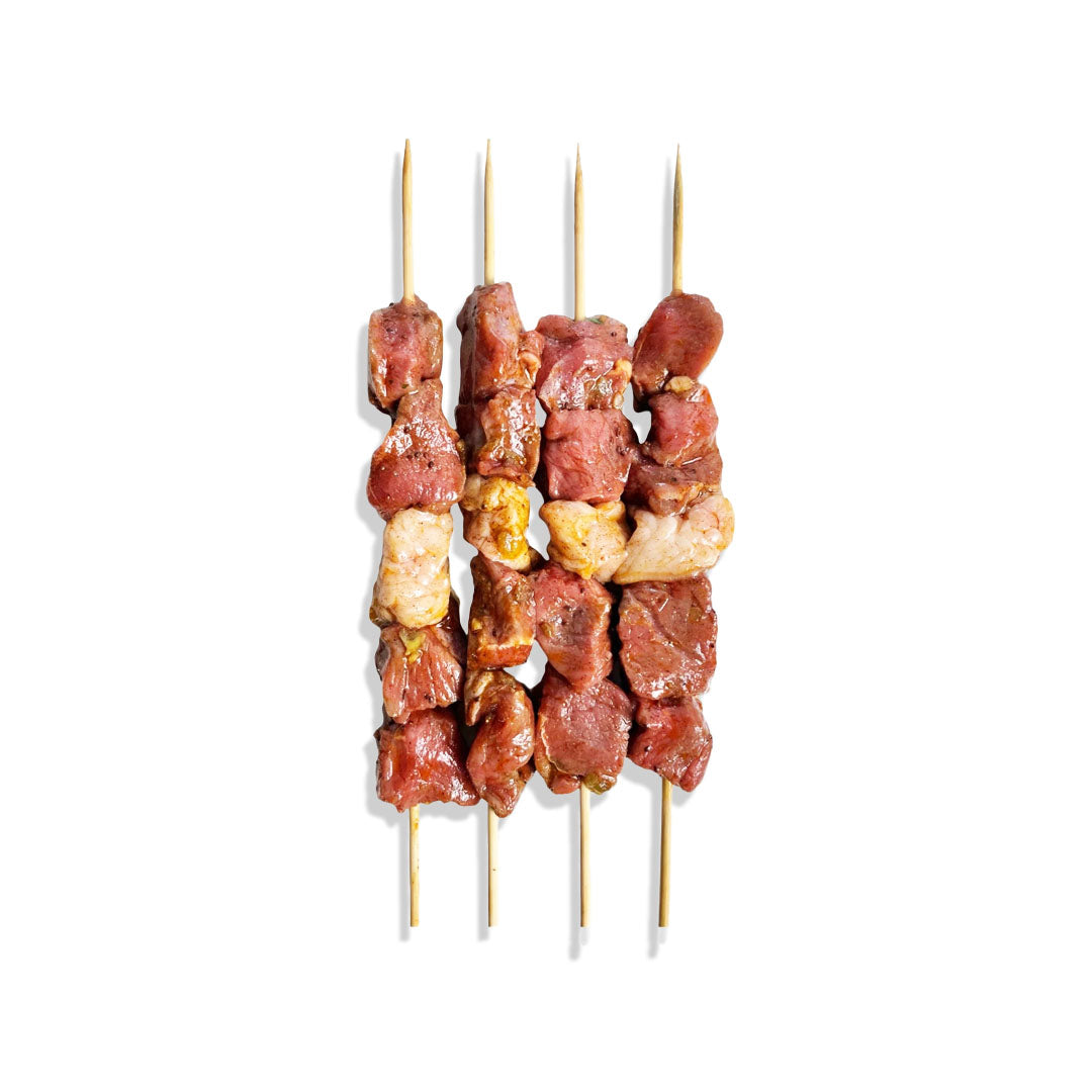 Skewers with marinated beef and vegetables on a white background