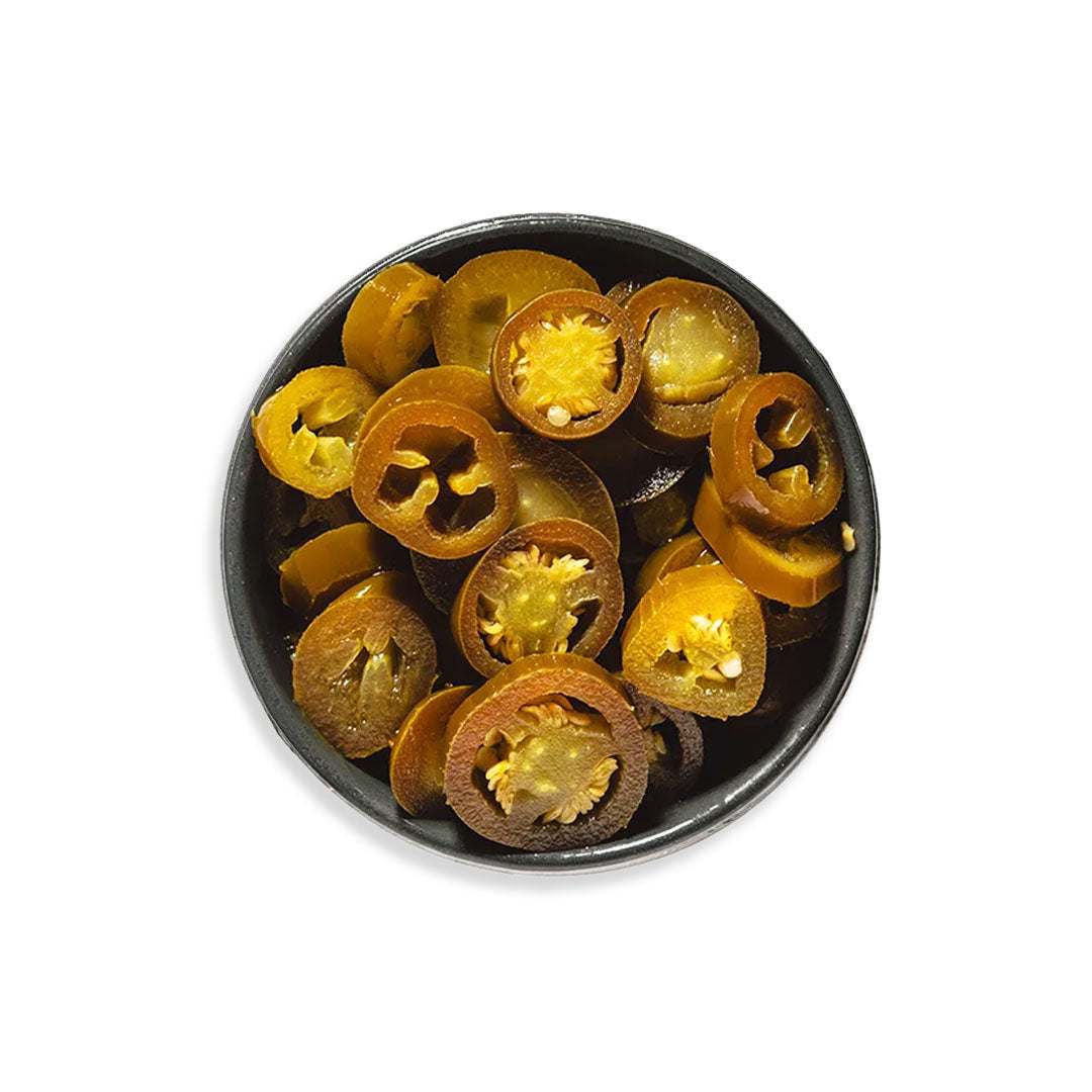 Sliced pickled jalapeños with vibrant green color and spicy tangy flavor in a jar