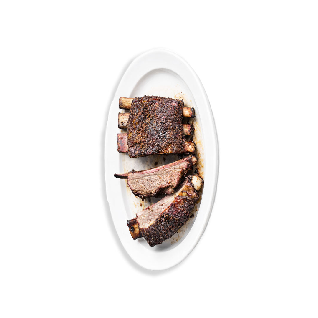 Sliced ribs on a white plate with a white background