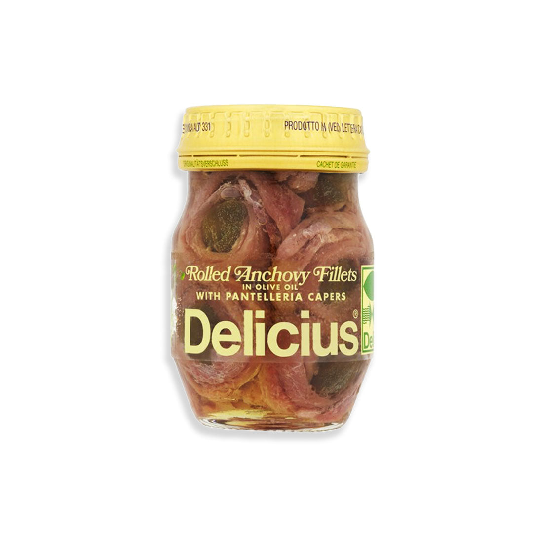 Jar of Delicius rolled anchovy fillets with a yellow lid on a white background