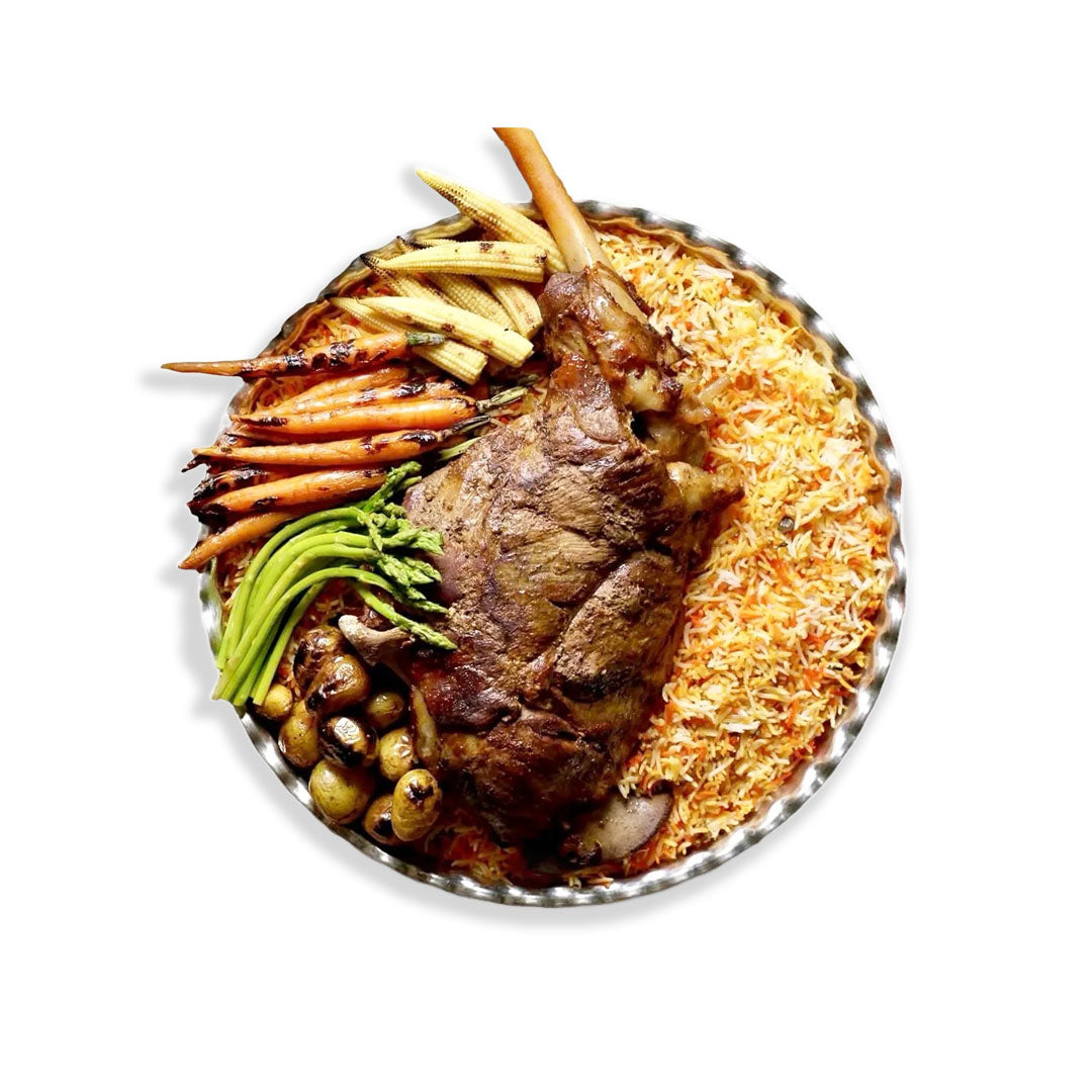 Plated dish with roasted vegetables and a piece of meat on a white background