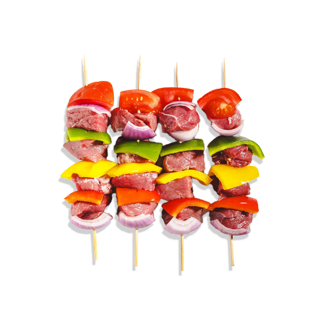 Skewers with sliced meat and vegetables on a white background