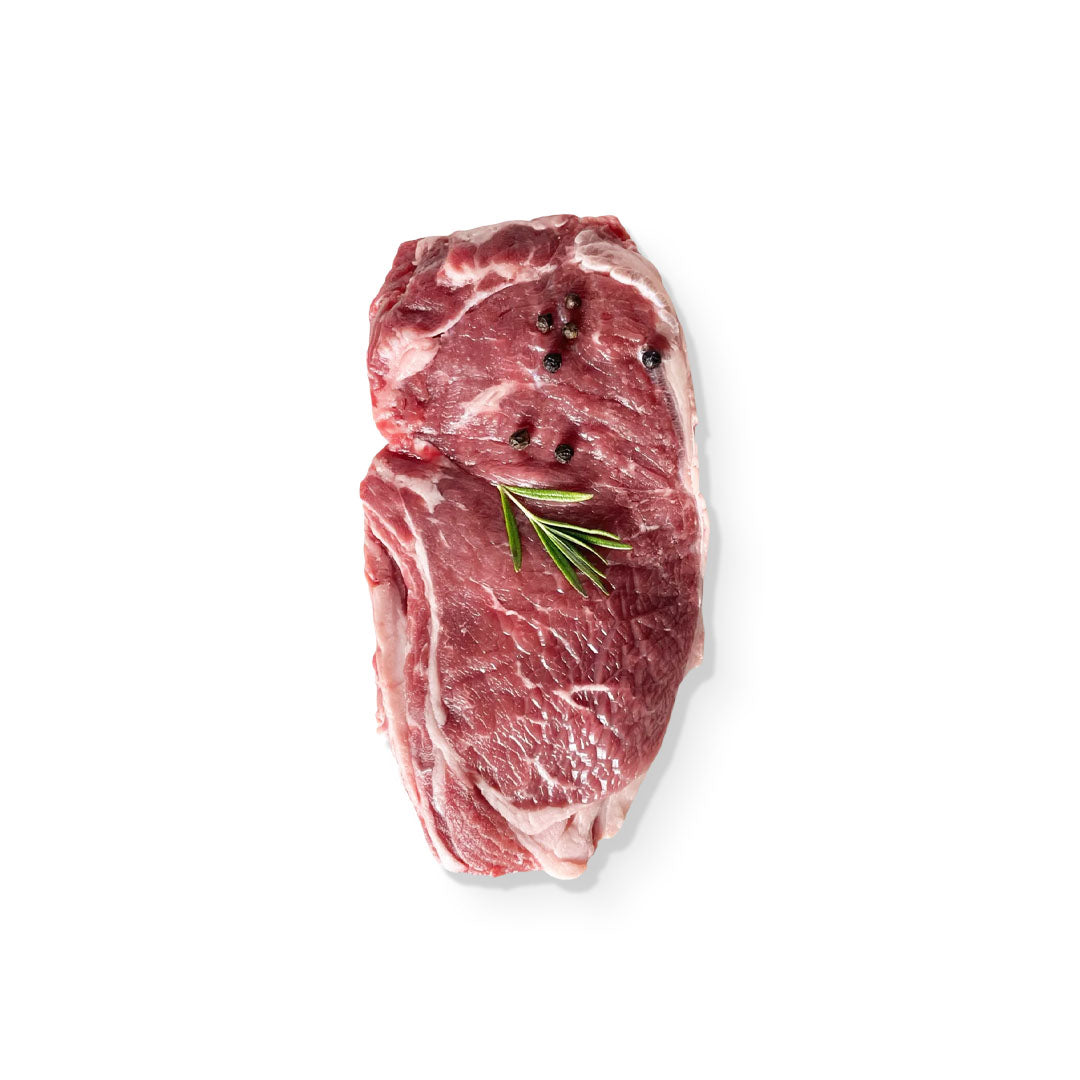 Raw steak with a sprig of rosemary on a white background