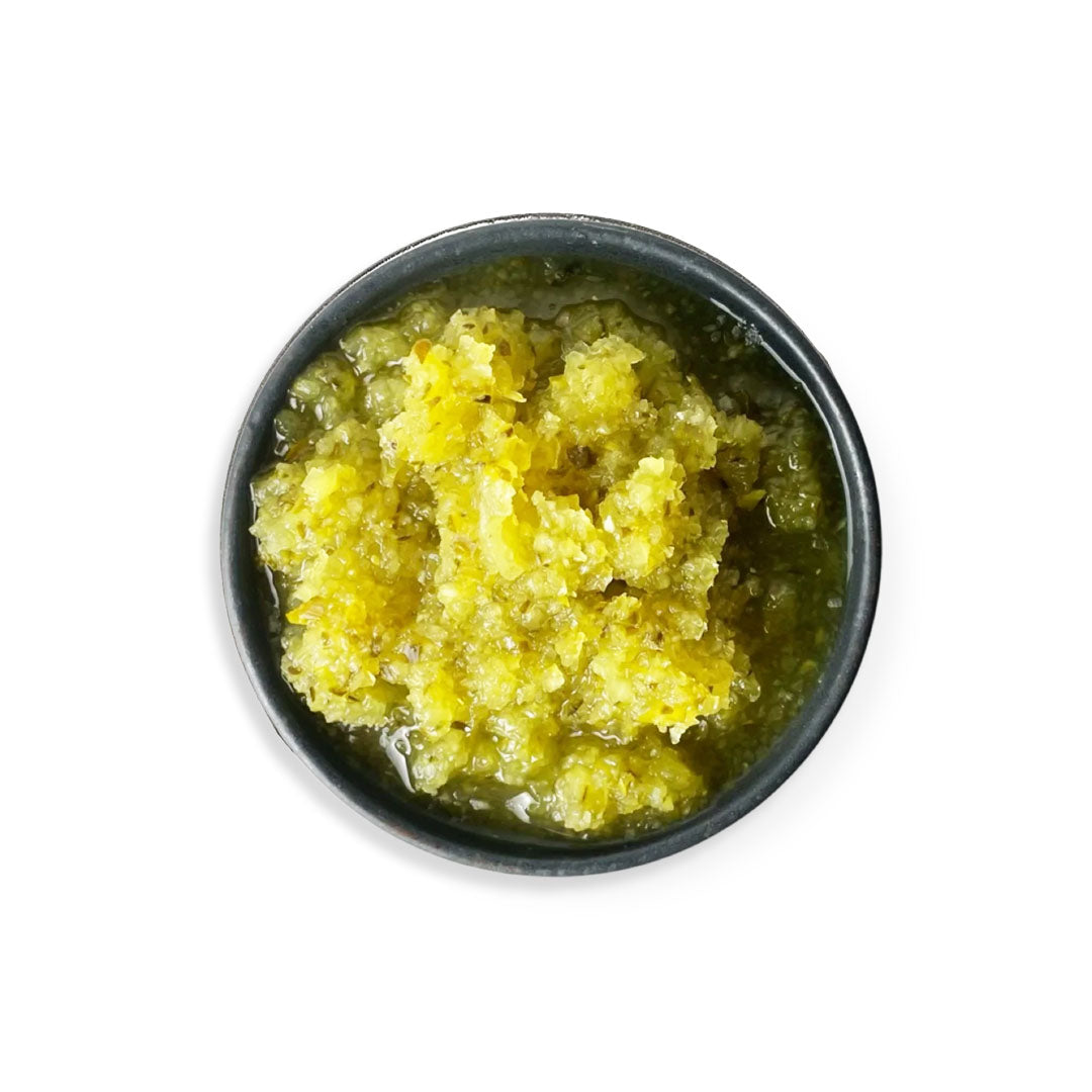 Black bowl filled with a yellowish-green substance on a white background