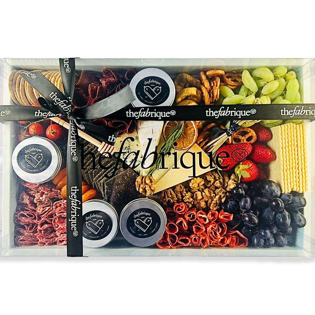 Assorted food items in a box with 'the fabrique' branding.