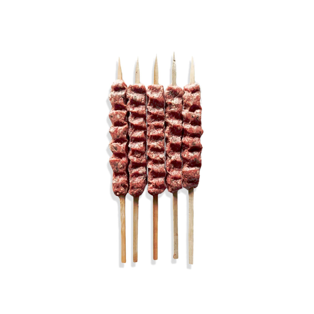 Skewers with cubes of meat on a white background