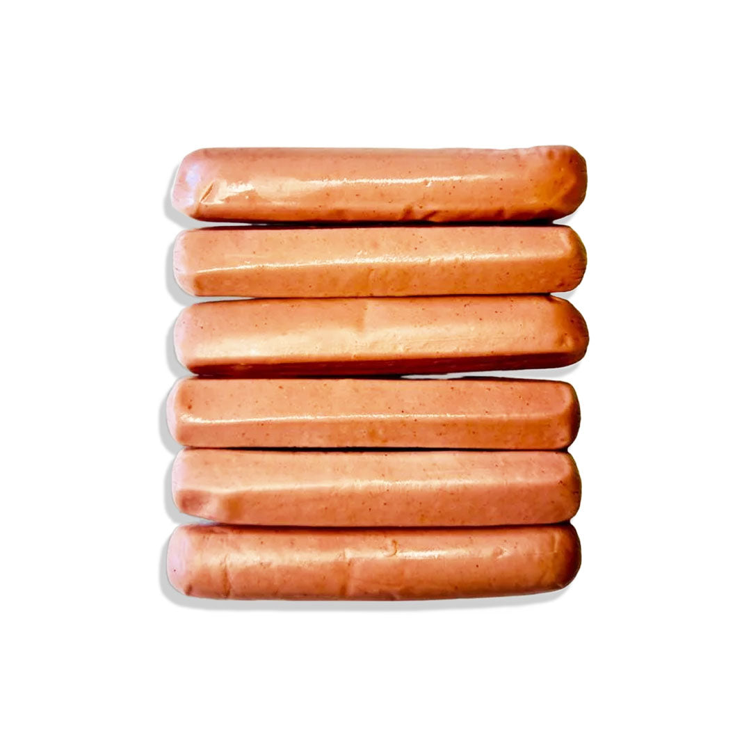 Stack of hot dogs in clear plastic packaging on a white background
