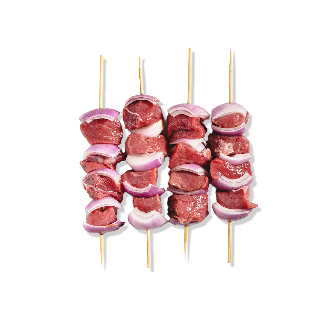 Three skewers with raw meat and onions on a white background