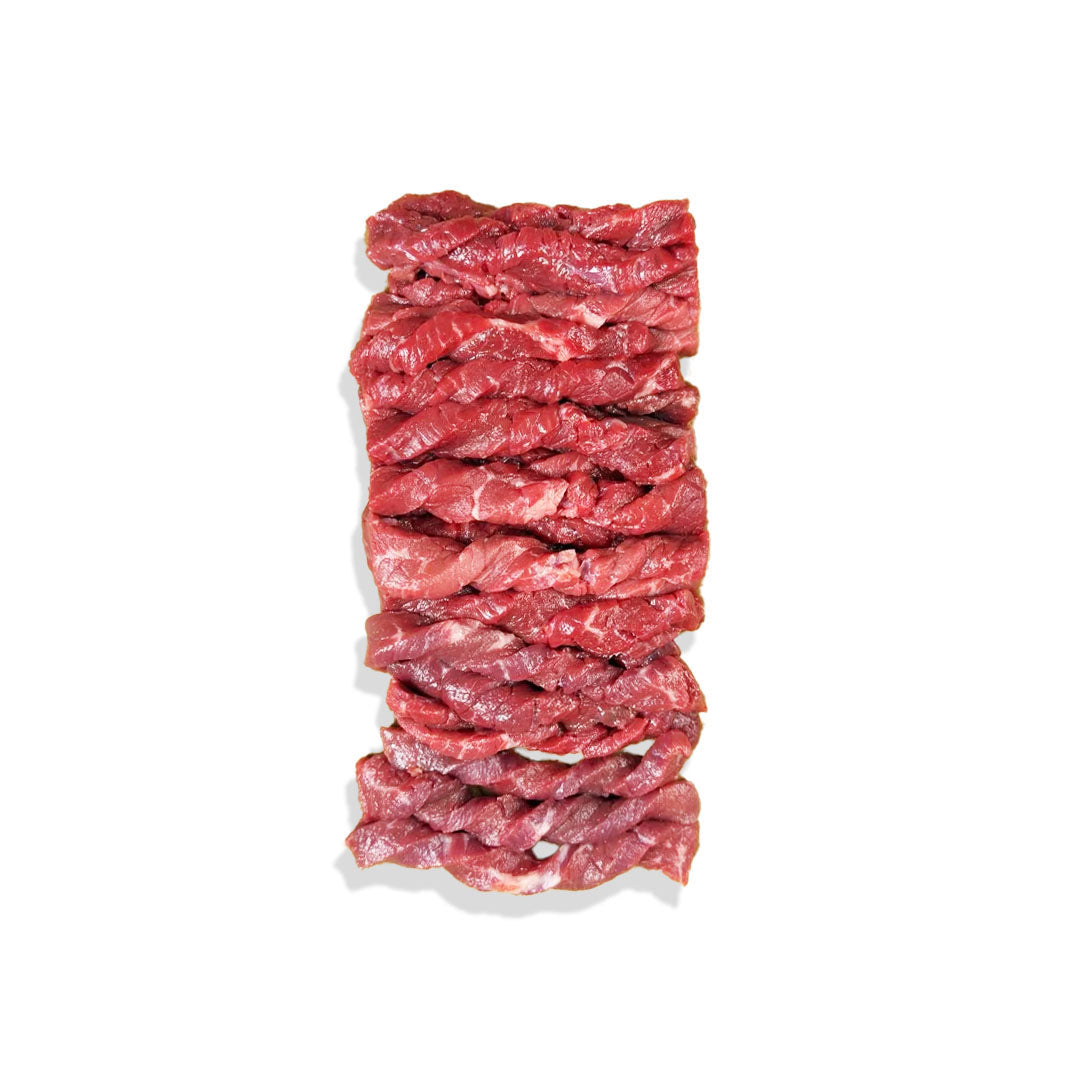 Stack of raw beef strips on a white background