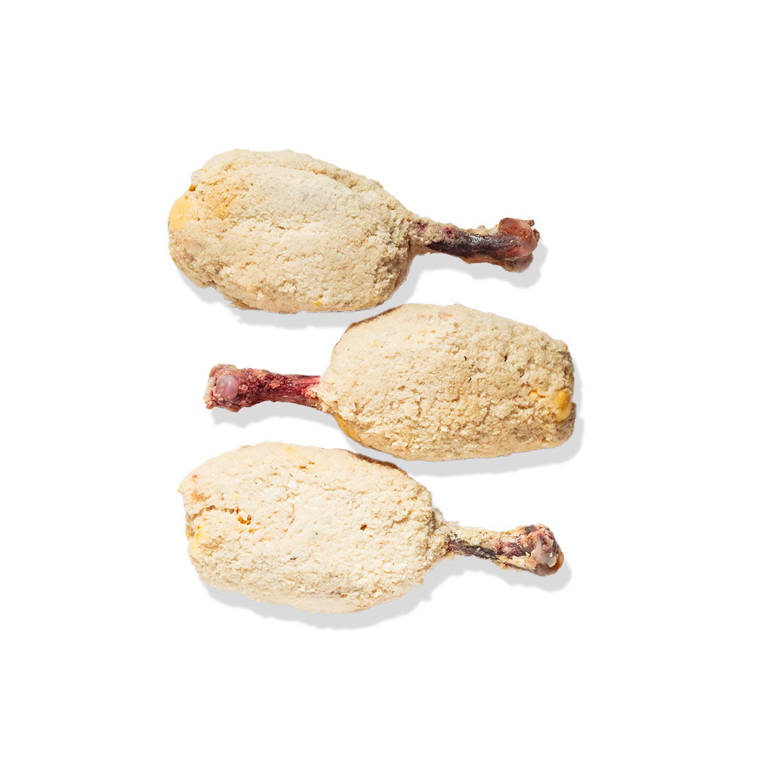 Three breaded chicken drumsticks on a white background