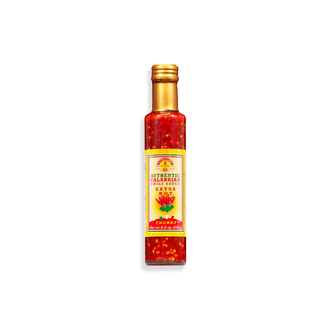 Bottle of hot sauce with a gold cap on a white background