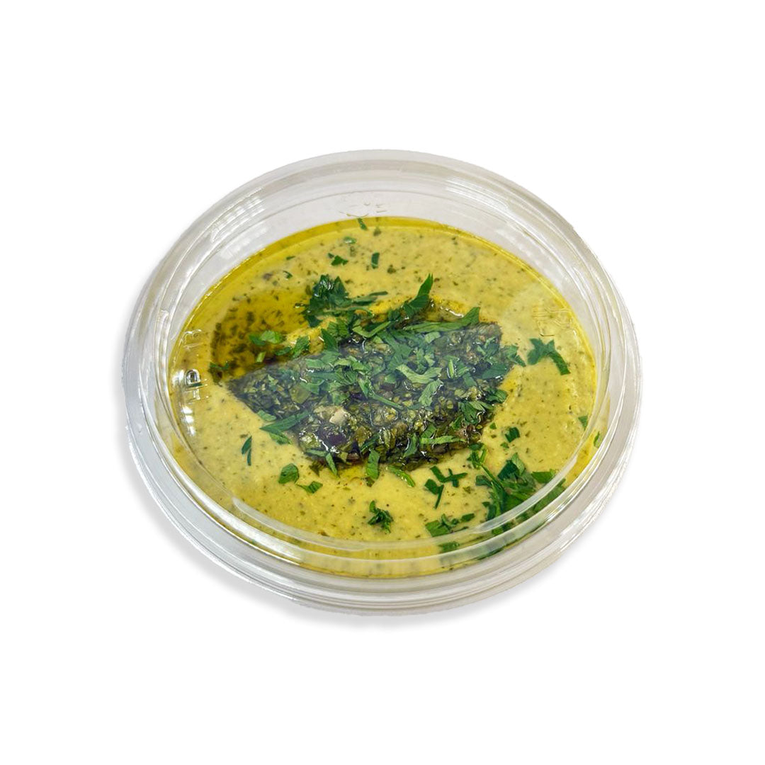 Green dip in a clear container with a white background