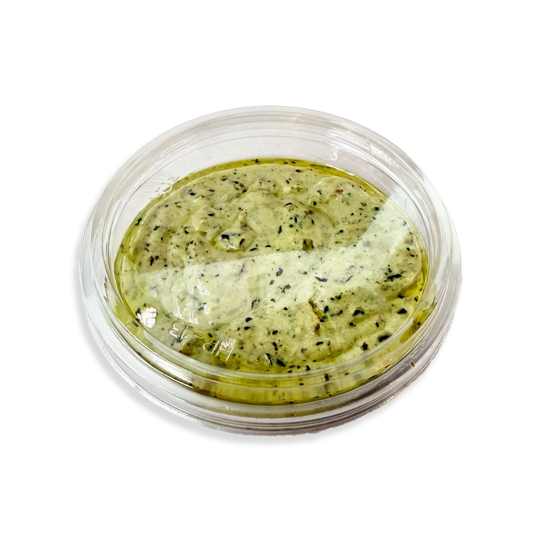 Green cream in a clear container on a white background