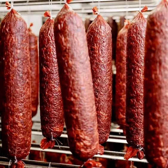 Row of dried sausages hanging on a rack.
