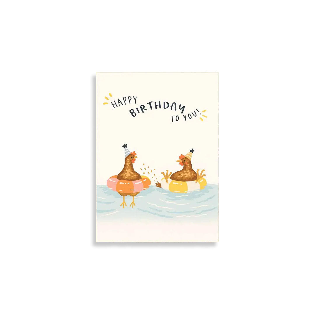 A square birthday greeting card featuring an illustration of two cartoon chickens floating in life preservers on water, with the text 'HAPPY BIRTHDAY TO YOU!' above them, shown against a plain white background.