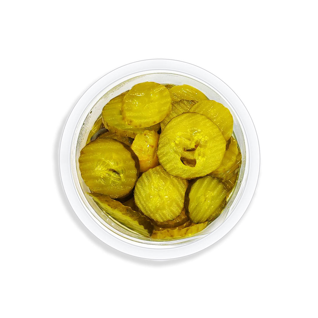 Container of pickled green cucumber on a white background