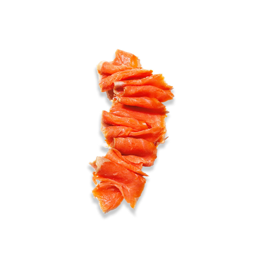A vertical stack of thin, curled orange-pink slices, likely salmon or a similar cured fish, isolated on a solid white background.