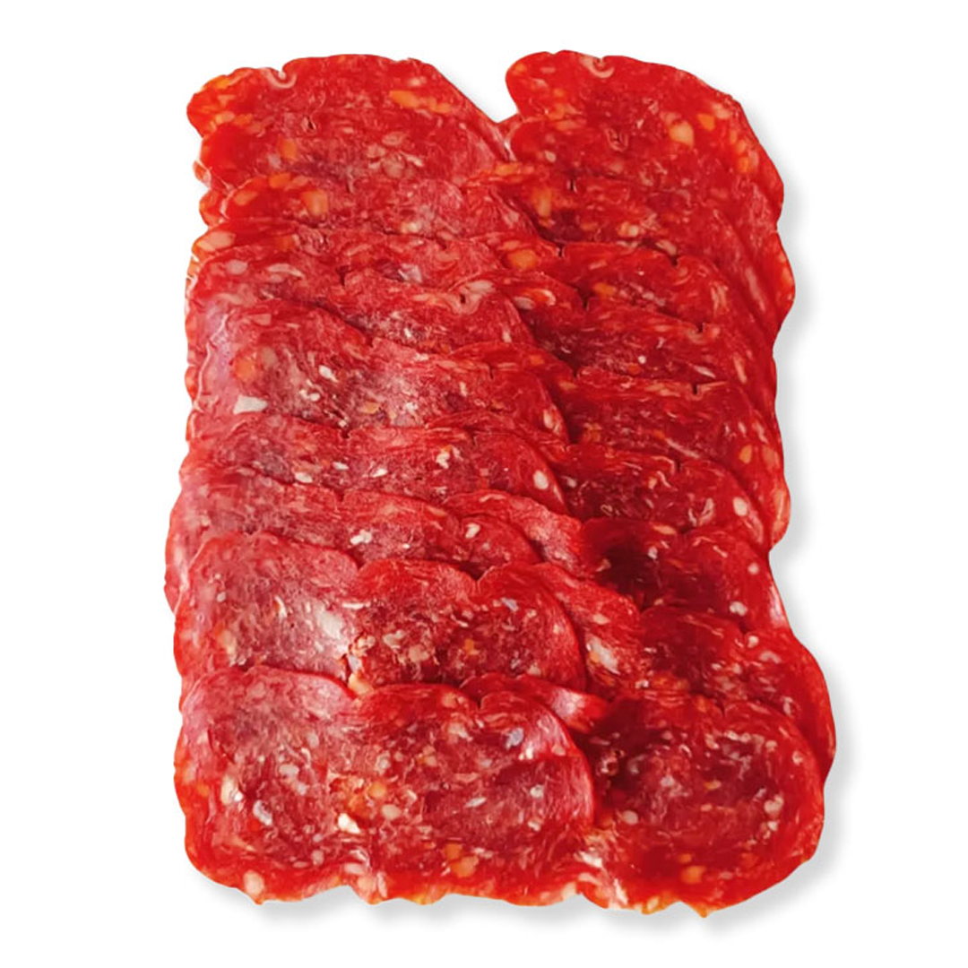 Sliced cured meat, likely salami or pepperoni, arranged in a neat stack on a white background.
